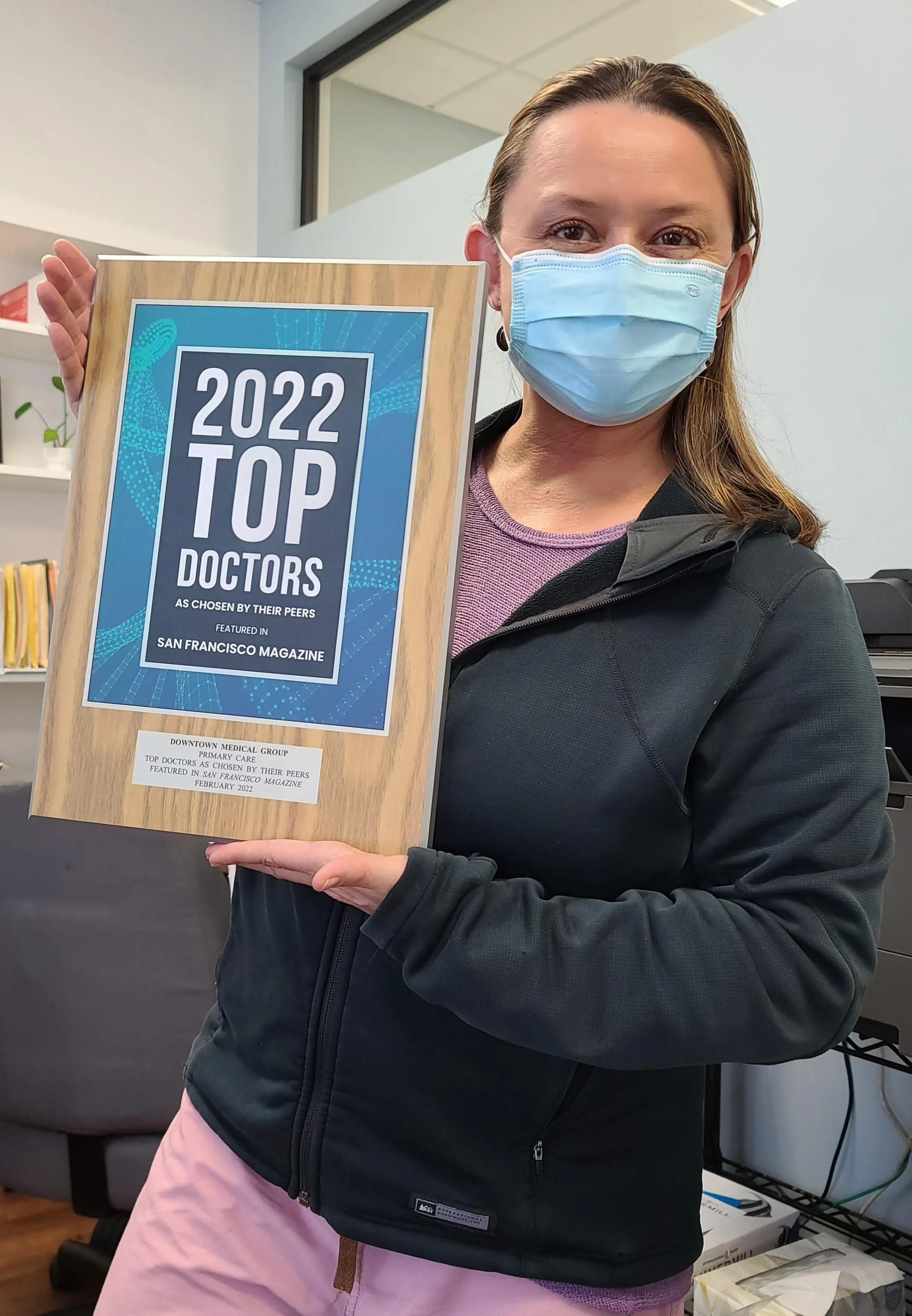 Dr. Elise Grenier holding Downtown Medical Group’s 2022 Top Doctors plaque.